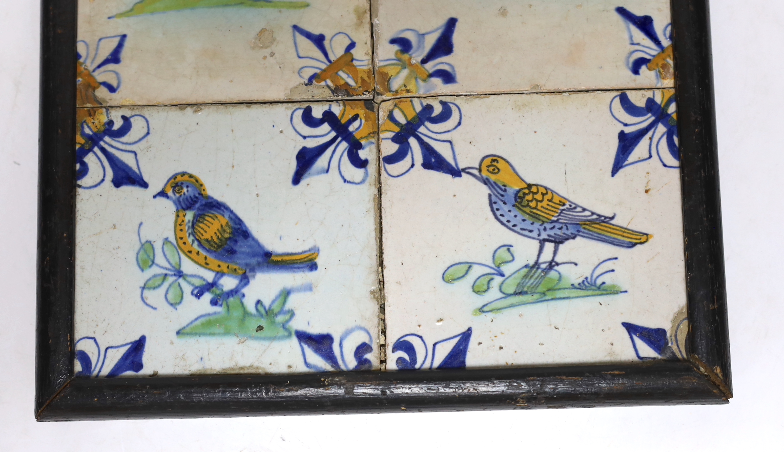 A 17th century Delft four-tile panel, polychrome-decorated with birds and with fleur-de-lys to corners (frame 28cm)